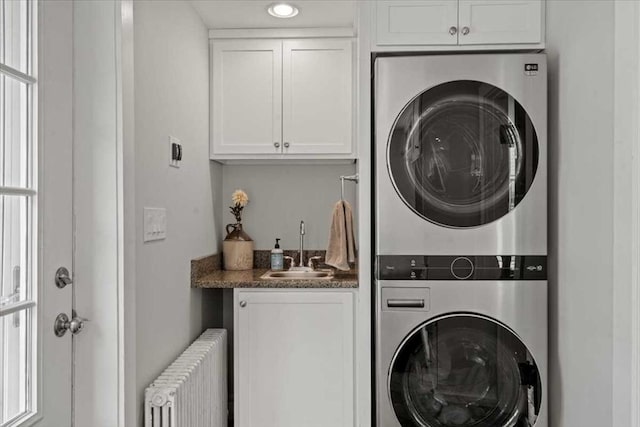 57 Highland St, Holden, MA 01520 - washroom featuring radiator heating unit, stacked washing machine and dryer, cabinet space, and recessed lighting