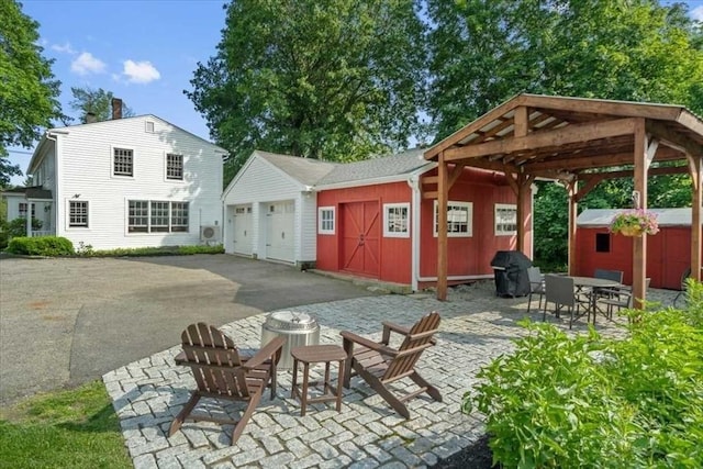 57 Highland St, Holden, MA 01520 - view of patio / terrace featuring an outdoor structure, a garage, area for grilling, and an outdoor fire pit