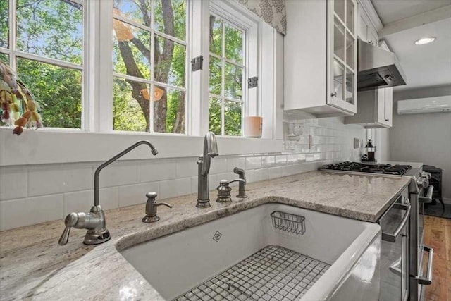 57 Highland St, Holden, MA 01520 - kitchen featuring a sink, stainless steel gas stove, tasteful backsplash, white cabinets, and glass insert cabinets