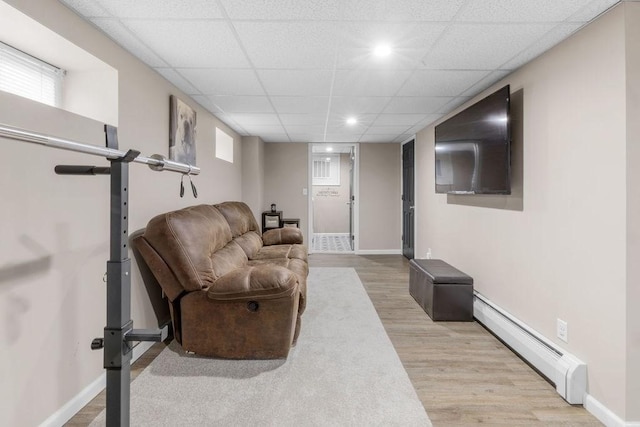 living room with a baseboard radiator and light wood-type flooring