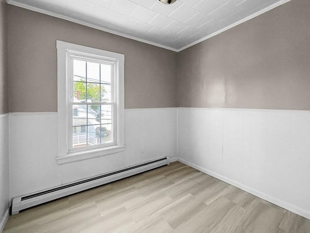 unfurnished room with baseboard heating and crown molding