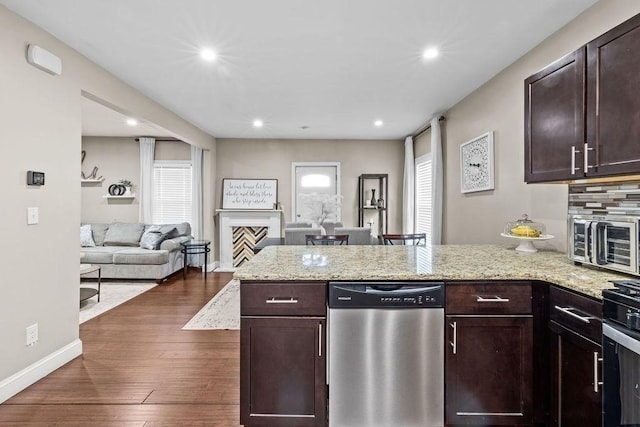 kitchen featuring light stone countertops, dark brown cabinetry, stainless steel dishwasher, and dark hardwood / wood-style floors