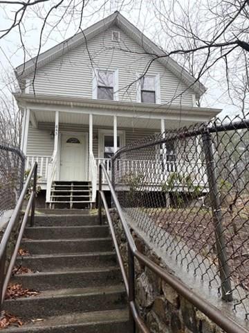 exterior space with fence, covered porch, and stairway