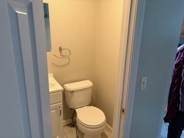 bathroom with tile patterned floors, vanity, baseboards, and toilet