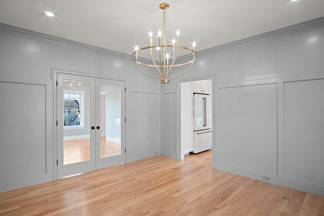 unfurnished dining area featuring a chandelier, french doors, light wood-type flooring, and crown molding