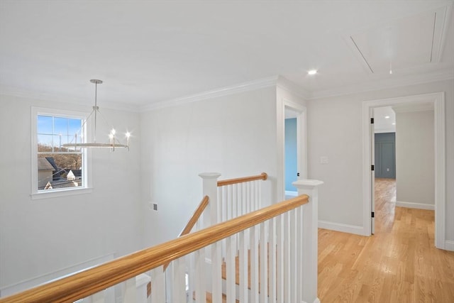 hallway featuring a chandelier, light wood-type flooring, and crown molding