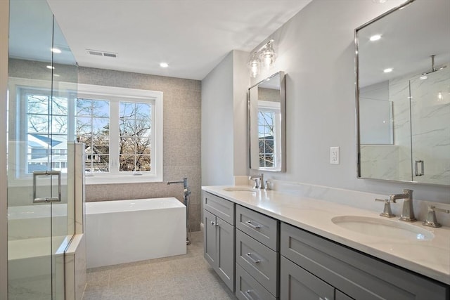 bathroom featuring vanity, a healthy amount of sunlight, and shower with separate bathtub