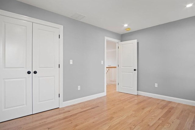 unfurnished bedroom featuring light hardwood / wood-style flooring and a closet