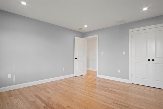 unfurnished bedroom with light wood-type flooring and a closet