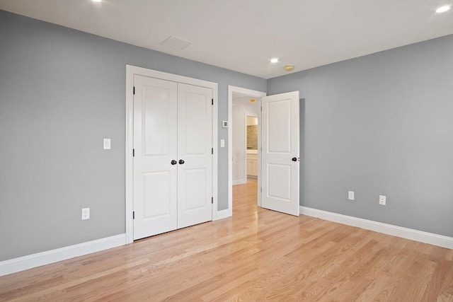 unfurnished bedroom featuring a closet and light wood-type flooring