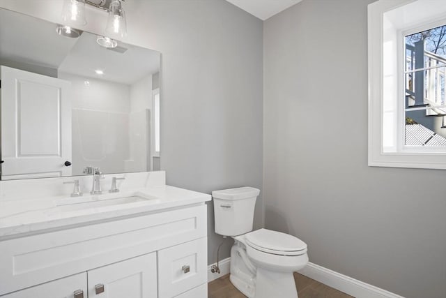 bathroom featuring hardwood / wood-style floors, vanity, a healthy amount of sunlight, and toilet