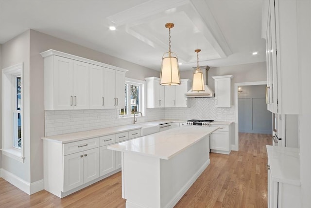 kitchen with premium range hood, tasteful backsplash, decorative light fixtures, white cabinets, and a center island