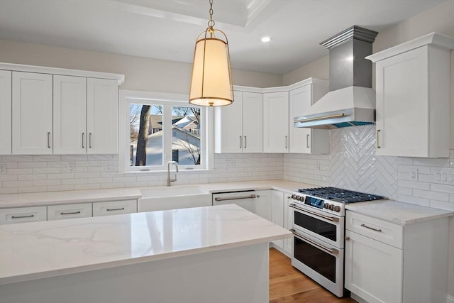 kitchen featuring tasteful backsplash, double oven range, wall chimney exhaust hood, and sink