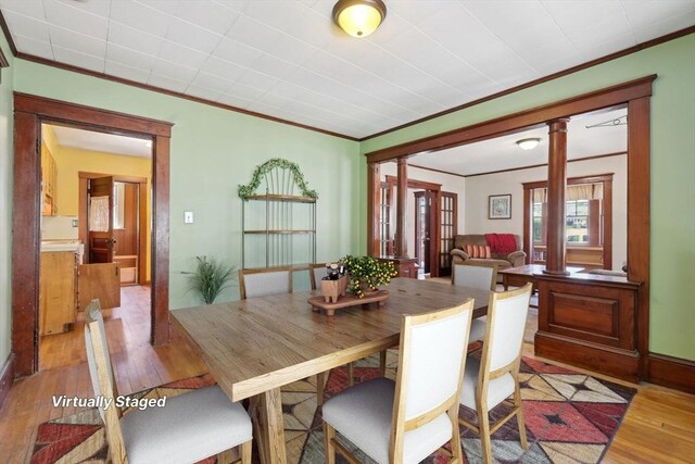26 W Walnut St, Milford, MA 01757 - dining area with crown molding, decorative columns, baseboards, and light wood-style floors
