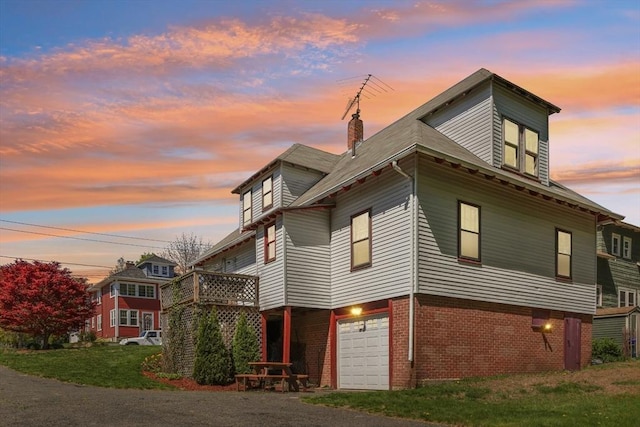 26 W Walnut St, Milford, MA 01757 - property exterior at dusk featuring brick siding, driveway, a chimney, and a garage