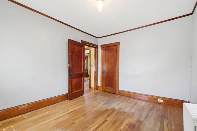 26 W Walnut St, Milford, MA 01757 - unfurnished room with crown molding, light wood-type flooring, baseboards, and radiator heating unit