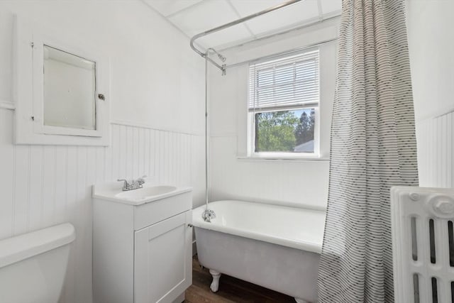 26 W Walnut St, Milford, MA 01757 - full bath featuring toilet, radiator, vanity, a freestanding tub, and a wainscoted wall