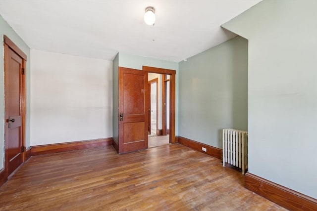 26 W Walnut St, Milford, MA 01757 - empty room featuring baseboards, radiator, and wood finished floors