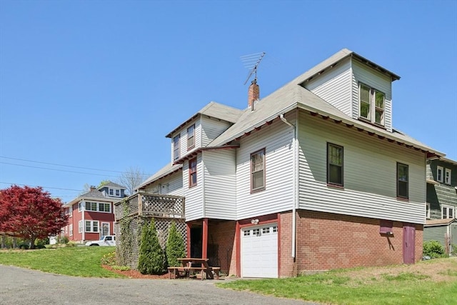 26 W Walnut St, Milford, MA 01757 - view of property exterior with a chimney, gravel driveway, brick siding, and an attached garage