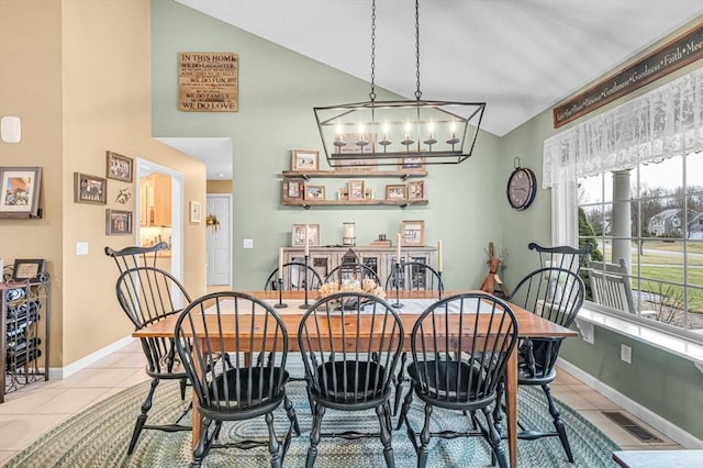 dining room with light tile patterned flooring, a chandelier, and vaulted ceiling