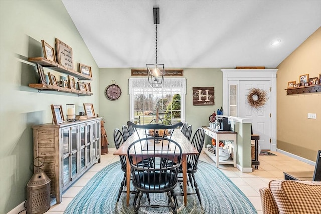 dining area featuring lofted ceiling and light tile patterned floors