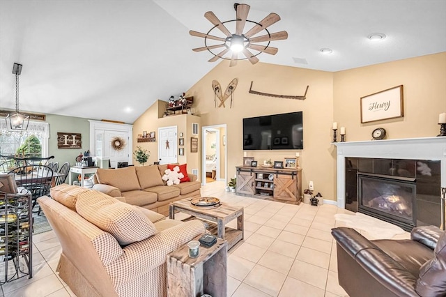 living room with ceiling fan, vaulted ceiling, light tile patterned flooring, and a fireplace