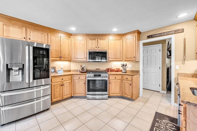 kitchen with light stone counters, appliances with stainless steel finishes, light tile patterned floors, and light brown cabinets