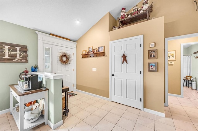 tiled foyer featuring lofted ceiling