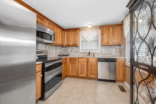 14 Watson St Unit 4, Lowell, MA 01852 - kitchen with appliances with stainless steel finishes, tasteful backsplash, light tile patterned floors, and plenty of natural light