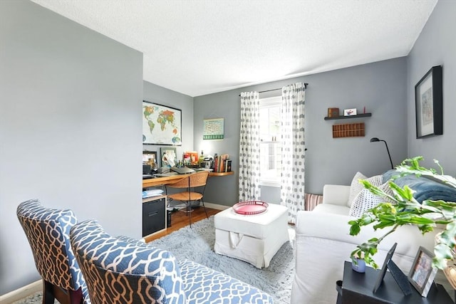 2480 Wilbraham Rd, Springfield, MA 01129 - living room featuring a desk, wood finished floors, a textured ceiling, and baseboards