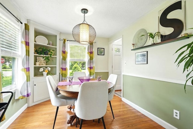 2480 Wilbraham Rd, Springfield, MA 01129 - dining space with light wood-type flooring, a textured ceiling, and baseboards