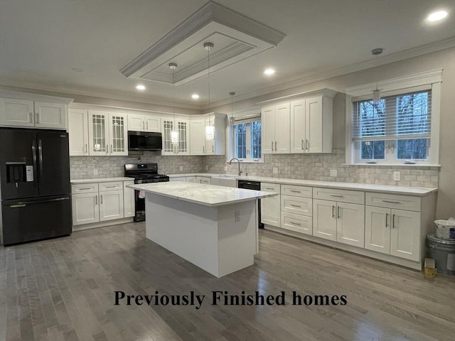 kitchen with white cabinetry, light countertops, black appliances, and dark wood-type flooring