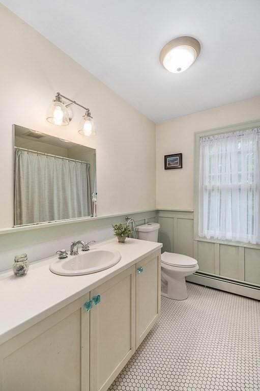 32 Witham St Unit B, Gloucester, MA 01930 - full bath with toilet, a baseboard radiator, vanity, and a wainscoted wall