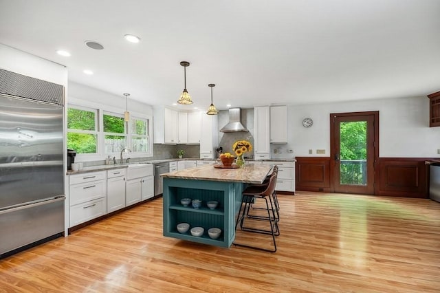 32 Witham St Unit B, Gloucester, MA 01930 - kitchen featuring stainless steel appliances, wall chimney range hood, open shelves, white cabinetry, and a sink