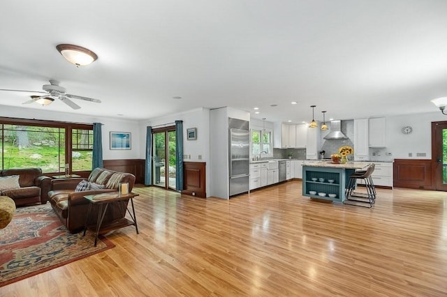 32 Witham St Unit B, Gloucester, MA 01930 - living room with light wood-style flooring, a ceiling fan, a wainscoted wall, and recessed lighting