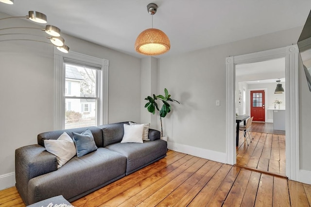 living area featuring wood-type flooring and baseboards