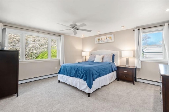 bedroom featuring a ceiling fan, a baseboard heating unit, and light colored carpet