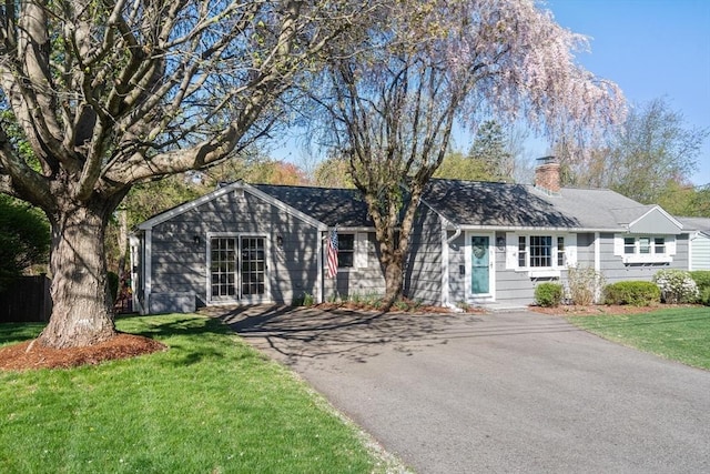 ranch-style home with a front lawn and a chimney
