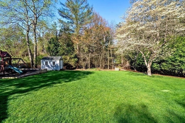 view of yard featuring an outbuilding, a playground, and a storage unit