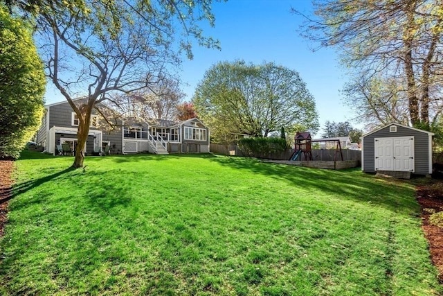 view of yard featuring an outdoor structure, fence, a sunroom, a playground, and a storage shed