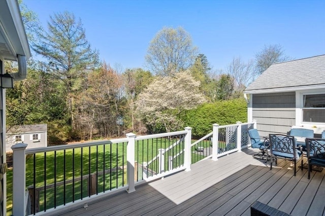 wooden deck with a yard, outdoor dining area, an outdoor structure, and a shed