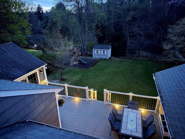 deck featuring an outbuilding, a yard, and a shed