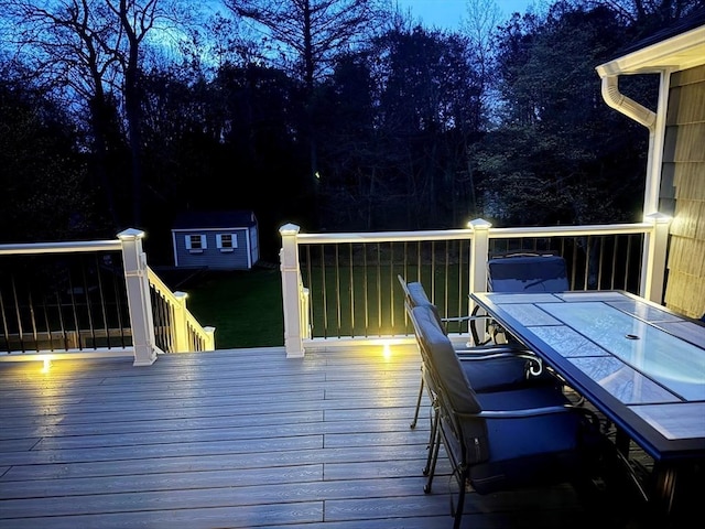 wooden deck featuring an outbuilding and outdoor dining area