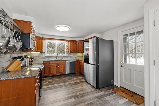 407 Mountain Rd, Jaffrey, NH 03452 - kitchen featuring dark wood-style flooring, backsplash, a sink, appliances with stainless steel finishes, and brown cabinetry