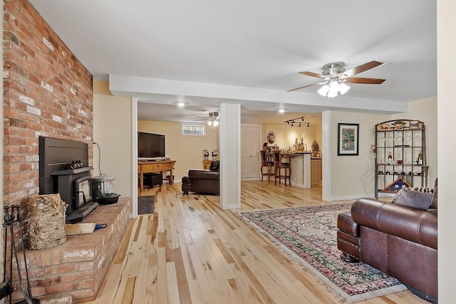 407 Mountain Rd, Jaffrey, NH 03452 - living room with wood-type flooring, baseboards, a wood stove, and ceiling fan
