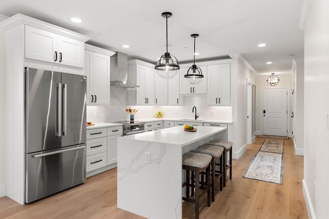 18 Franklin Unit 303A, Salem, MA 01970 - kitchen featuring stainless steel appliances, wall chimney exhaust hood, a sink, a breakfast bar, and a kitchen island