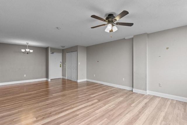 unfurnished living room with a chandelier, light wood-style floors, ceiling fan, and baseboards