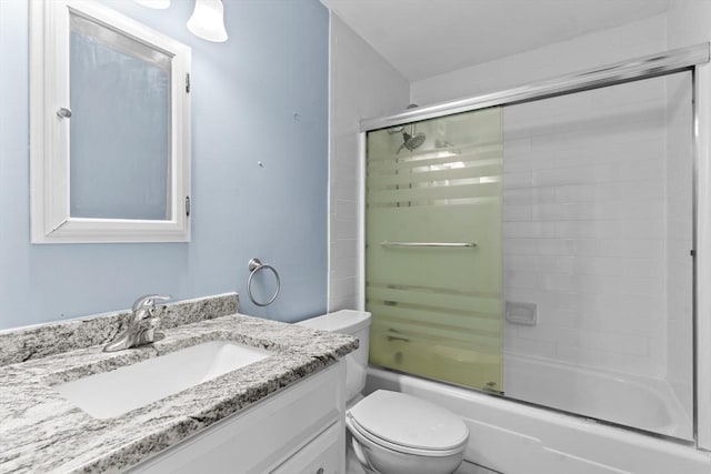 full bath featuring vanity, toilet, and combined bath / shower with glass door