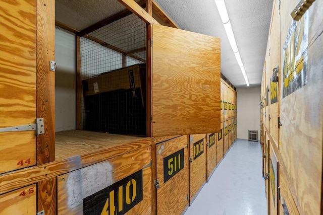 corridor featuring finished concrete floors and a textured ceiling
