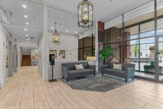 common area featuring floor to ceiling windows, stairs, and a towering ceiling
